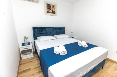 a bedroom with a bed with slippers on it at Vukotic in Budva