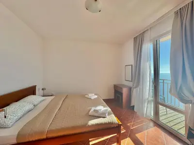a bedroom with a bed with a view of the ocean at Calma Vista Apartments by Vila Vanja in Budva