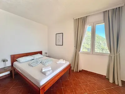 a bedroom with a bed and a large window at Calma Vista Apartments by Vila Vanja in Budva