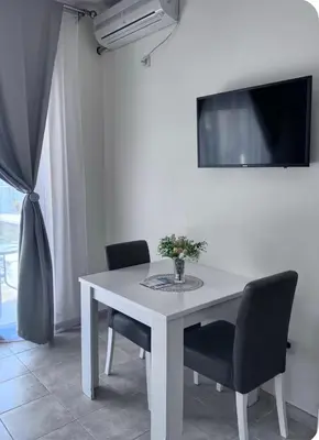 a white dining room table with chairs and a tv at Apartments Sofia in Kotor