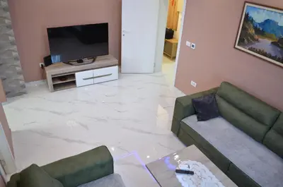 a living room with a couch and a flat screen tv at Apartman Kika in Sutomore