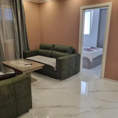 a living room with a green couch and a table at Apartman Kika in Sutomore