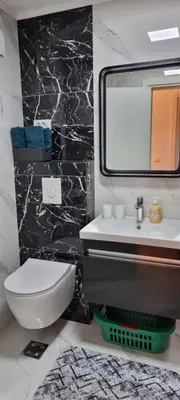 a bathroom with a white toilet and a mirror at Apartman Kika in Sutomore