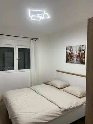 a white bedroom with a bed and a window at Lucky in Babalonija
