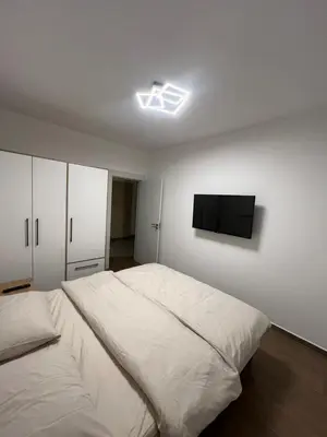 a bedroom with a bed and a flat screen tv on the wall at Lucky in Babalonija