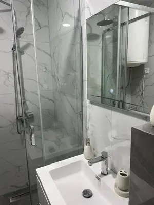 a bathroom with a sink and a shower with a mirror at Lucky in Babalonija