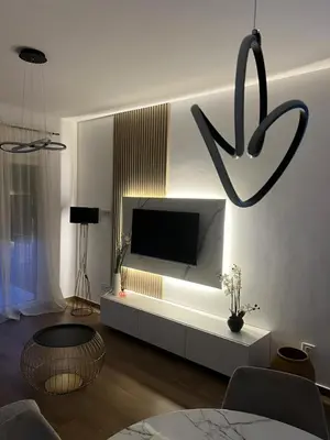 a living room with a flat screen tv and a table at Lucky in Babalonija