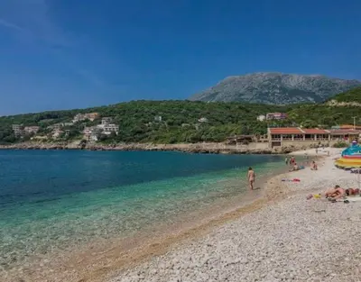 a group of people on a beach near the water at Utjeha Montenegro in Masline