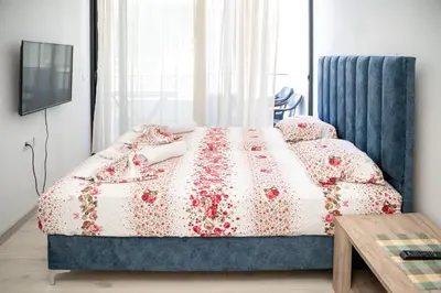 a bedroom with a bed with a floral bedspread at You GO in Velika Plaža