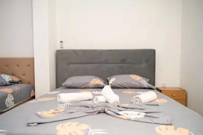 a bed with a gray headboard and pillows at You GO in Velika Plaža