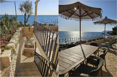 a wooden table with an umbrella and the ocean at SeiSensi Luxury Beach Villa in Gornji Sušanj