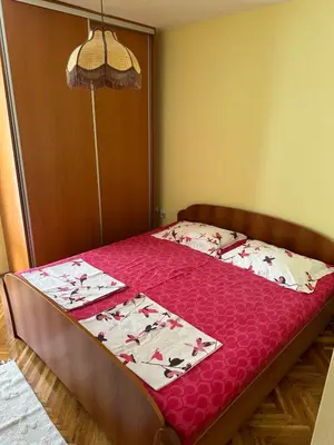 a bedroom with a bed with a red bedspread at Sea View Budva in Komoševina