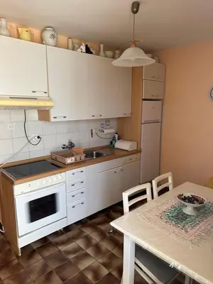 a kitchen with a table and a white stove top oven at Sea View Budva in Komoševina