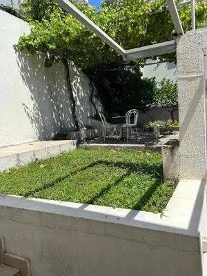 a chair sitting on the grass in a garden at Sea View Budva in Komoševina