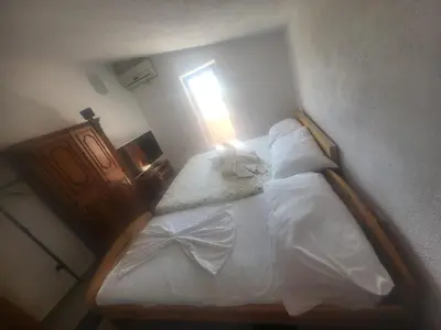 a bedroom with a bed with white sheets and a window at Apartment Asko in Ulcinj