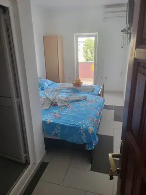 a bedroom with a bed with blue sheets and a window at Apartment Asko in Ulcinj