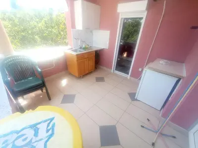 a kitchen with a table and a chair and a refrigerator at Apartment Asko in Ulcinj