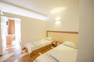 a hotel room with two beds and a window at Lana Apartments Nr 11 in Ulcinj