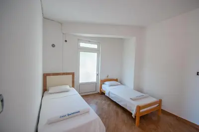 two beds in a room with a window at Lana Apartments Nr 1 in Ulcinj