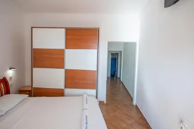a bedroom with a bed and a wooden headboard at Lana Apartments Nr 1 in Ulcinj