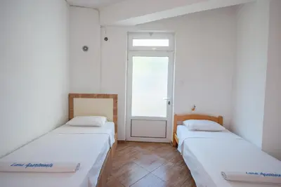 two beds in a room with a window at Lana Apartments Nr 1 in Ulcinj