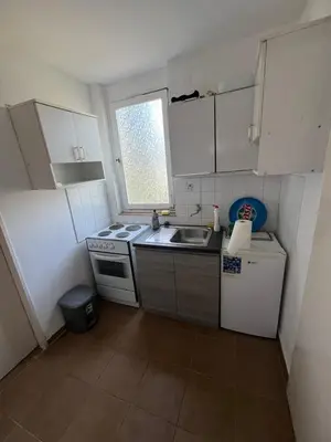 a small kitchen with a sink and a refrigerator at Garsonjera Ulcinj in Ulcinj