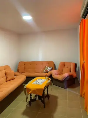 a living room with two couches and a table at Garsonjera Ulcinj in Ulcinj