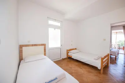 a bedroom with two beds and a room with a window at Lana Apartments Nr 3 in Ulcinj