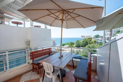 a wooden table with chairs and an umbrella on a balcony at Lana Apartments Nr 3 in Ulcinj