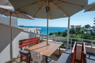 a wooden table and chairs on a balcony with an umbrella at Lana Apartments Nr 2 in Ulcinj