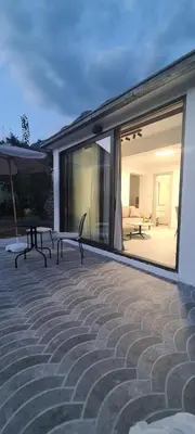 a patio with two benches and an umbrella at Apartman Vesna in Kotor
