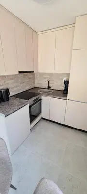 a kitchen with white cabinets and a sink at Apartman Vesna in Kotor
