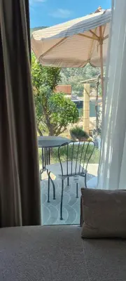 a patio with a table and an umbrella at Apartman Vesna in Kotor