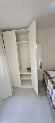 a white room with a bed and a closet at Apartman Vesna in Kotor