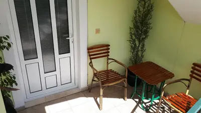 a porch with two chairs and a table next to a door at Apartments Simo in Petrovac na Moru