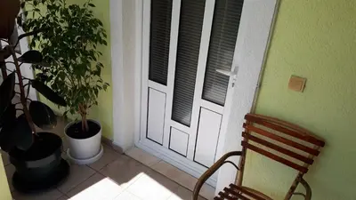 a door with a chair and a plant next to it at Apartments Simo in Petrovac na Moru