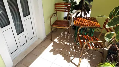 two chairs sitting on a porch next to a door at Apartments Simo in Petrovac na Moru