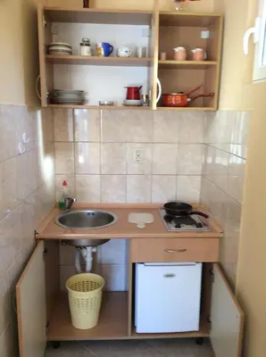 a small kitchen with a sink and a stove at Apartments Simo in Petrovac na Moru