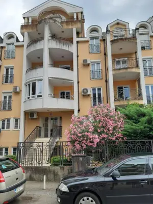 a large building with cars parked in front of it at Apartman Ljubovic F in Podgorica