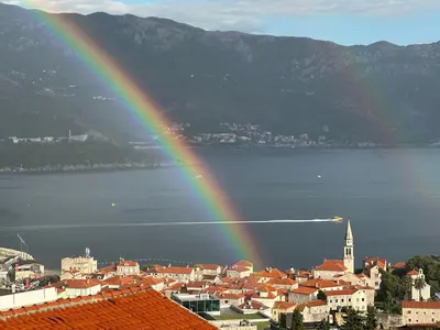a rainbow over a city with a town and the water at Sea View Budva in Budva