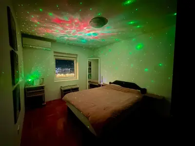 a bedroom with a bed with green lights on the ceiling at Sea View Budva in Budva