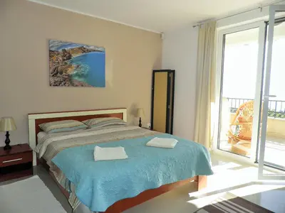 a bedroom with a bed and a large window at Bay View Apartments in Petrovac na Moru