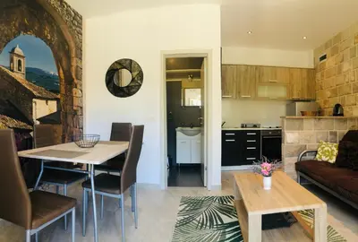 a kitchen and living room with a table and a couch at Bay View Apartments in Petrovac na Moru