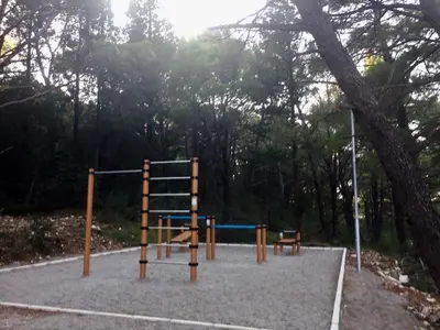 a playground in a park with a tree at Bay View Apartments in Petrovac na Moru