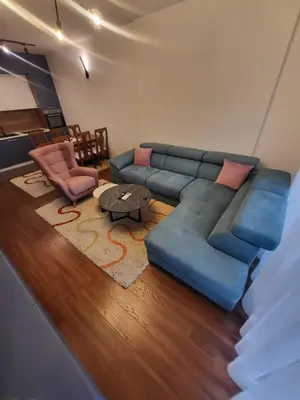 a living room with a blue couch and a table at Master apartment in Kruševac