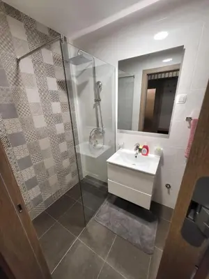 a bathroom with a white sink and a shower at Master apartment in Kruševac