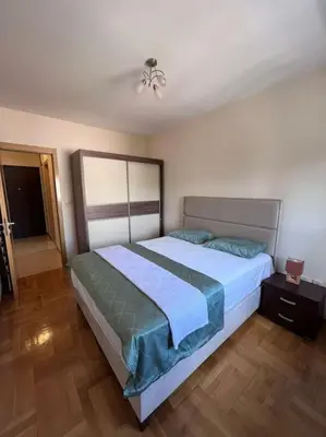 a bedroom with a large bed with a blue blanket at Charming and nature surrounded in Podgorica
