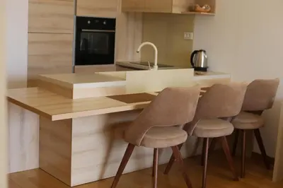 a kitchen with a counter with four chairs at a kitchen island at AKS Aparments - Wow in Budva