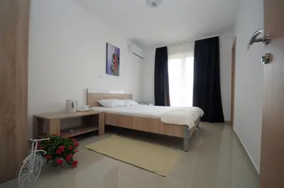 a bedroom with a bed and a table and a window at Apartments Vila Anastasia in Budva