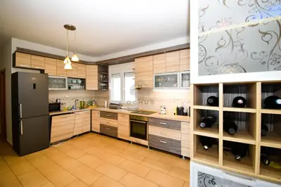 a large kitchen with a black refrigerator and wooden cabinets at Baloci hills in Gornja Gorica